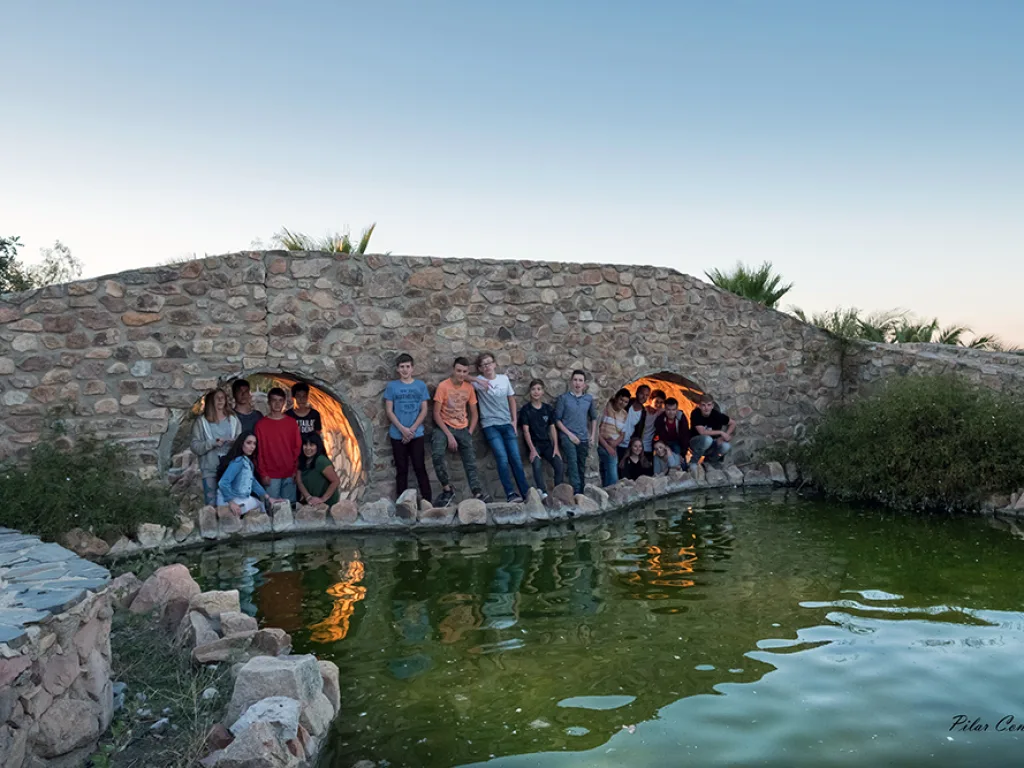 Die Gruppe steht auf einer Steinbrücke, die sich im Wasser spiegelt.
